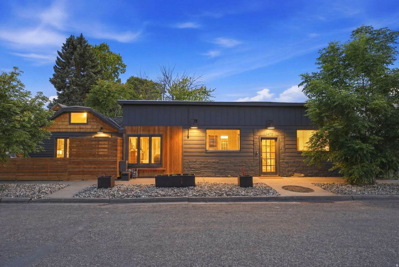 Contemporary exterior featuring multiple siding textures, wood paneling, dark horizontal siding, and stone accents