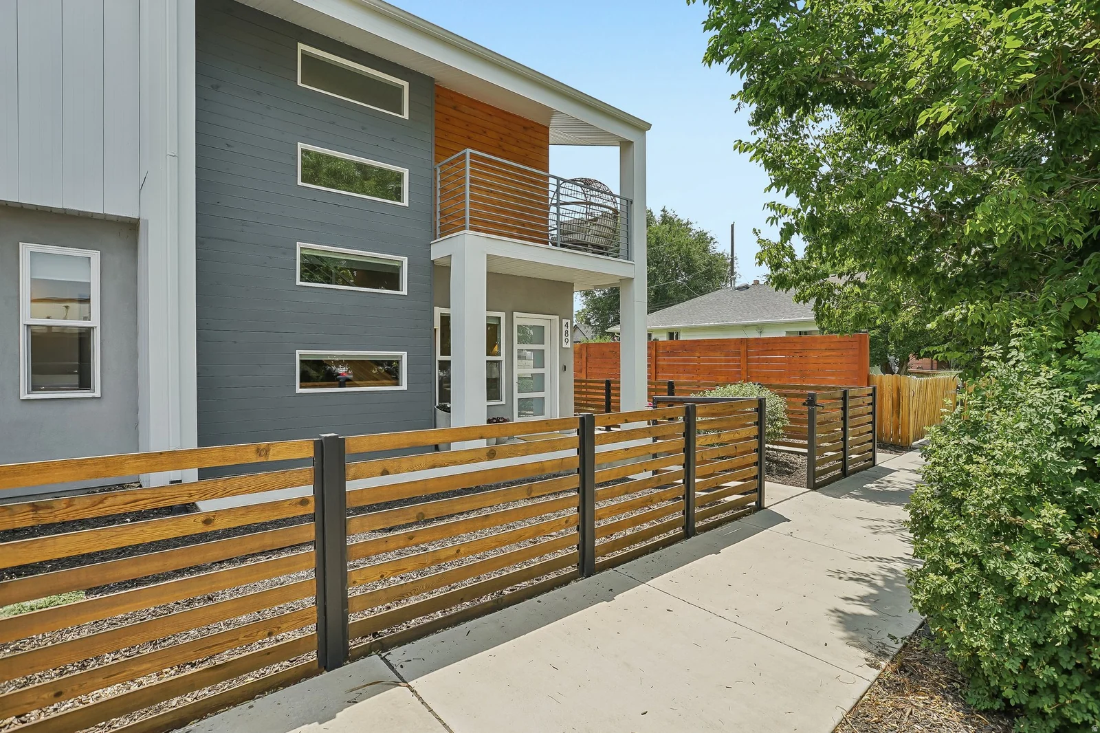 Contemporary exterior featuring gray siding with wood accents