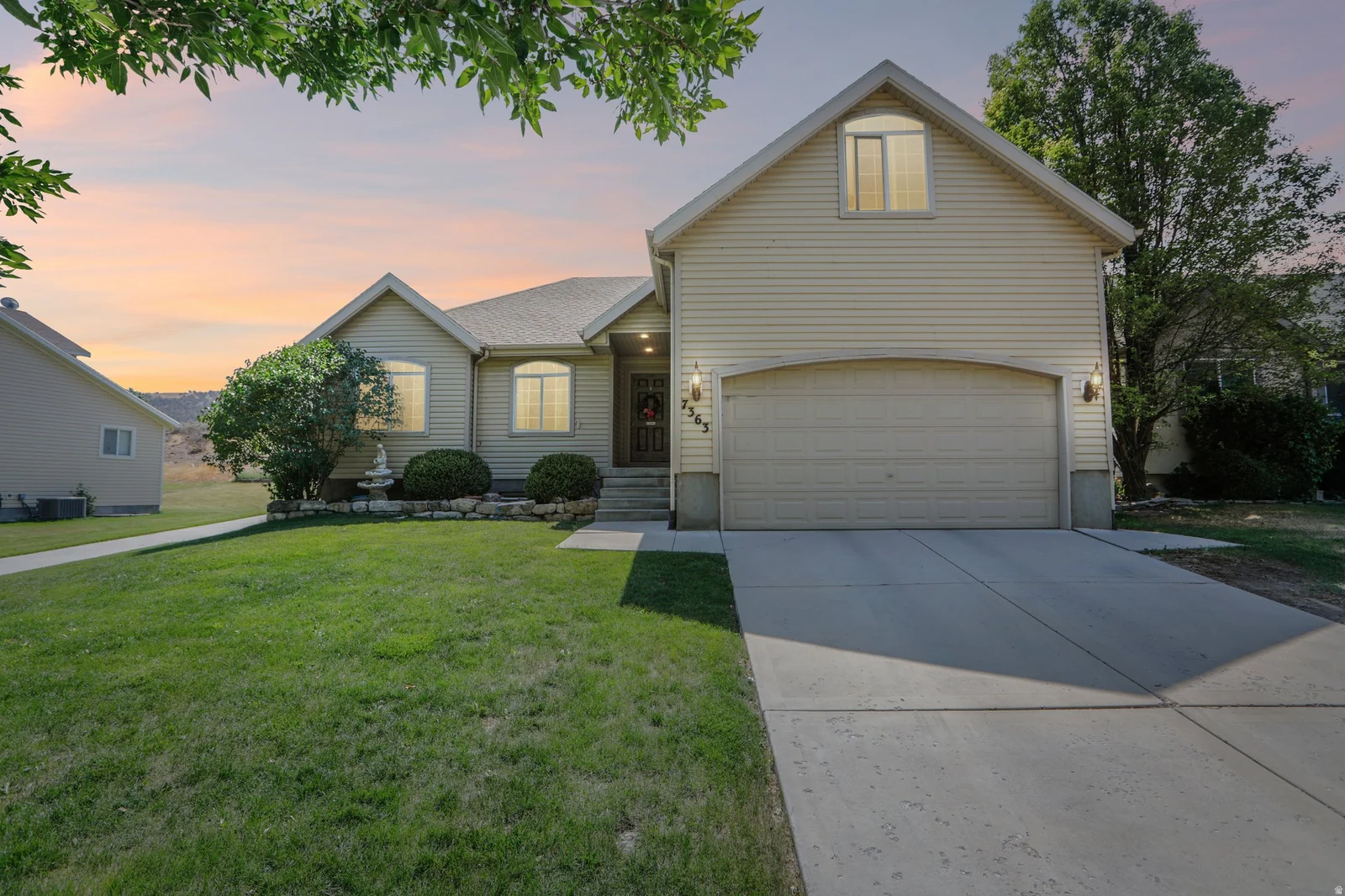 Two-story residence featuring light-colored siding and a two-car garage