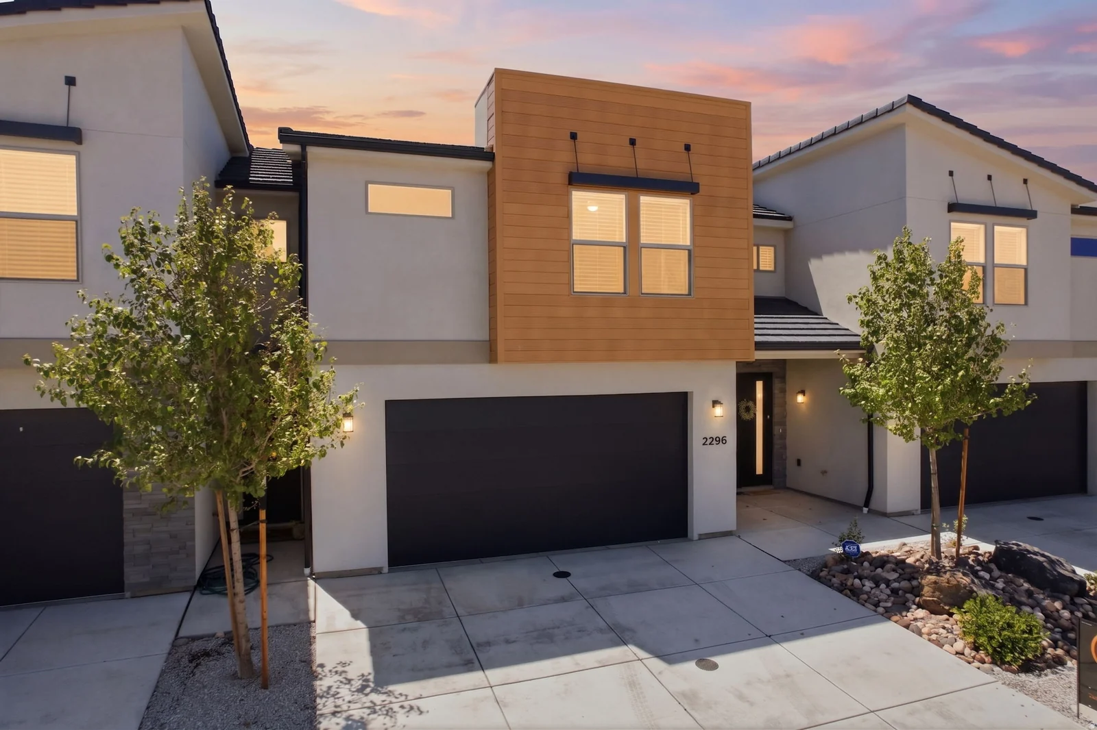 Contemporary townhome facade featuring a prominent wood-finish panel accent