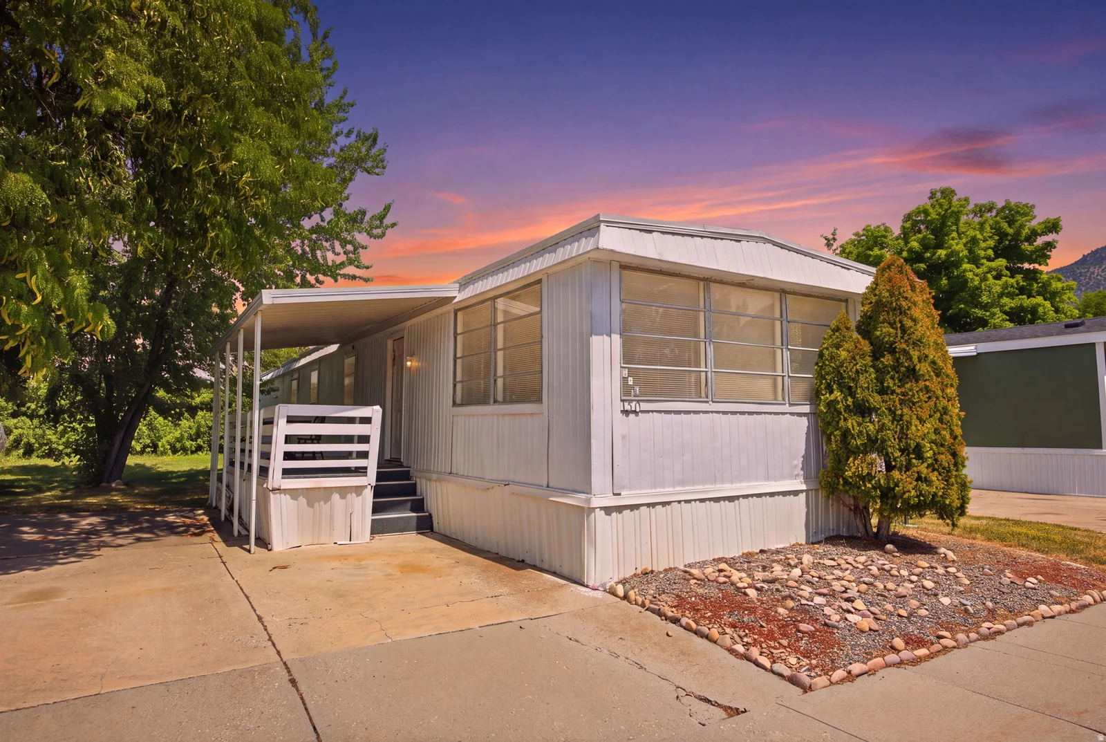 White exterior with a covered porch and concrete driveway
