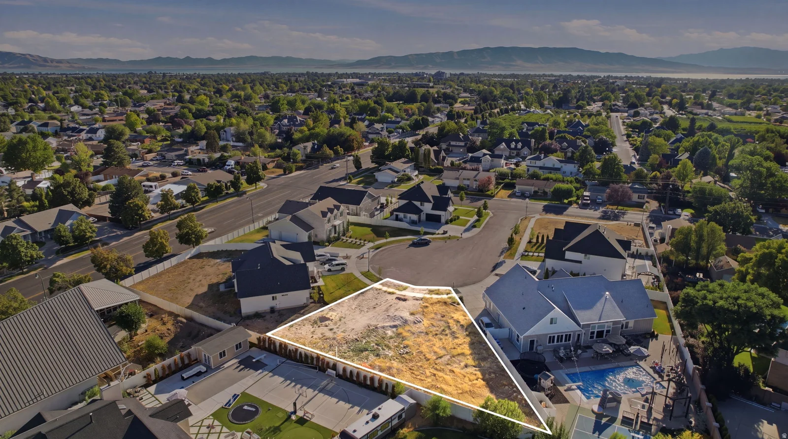 Expansive vacant land parcel featuring a level building site, surrounded by established residences