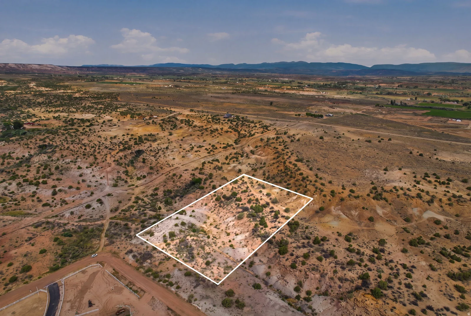 Expansive land parcel with natural terrain and scattered vegetation