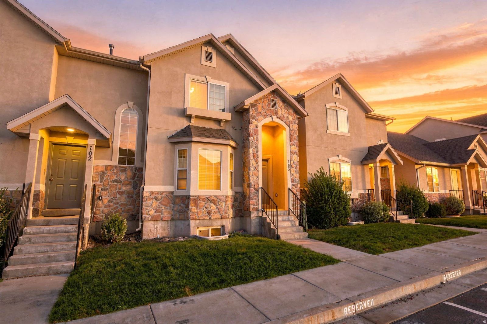 Stucco exterior with stone accents, bay window, arched window, covered entries, and concrete walkways