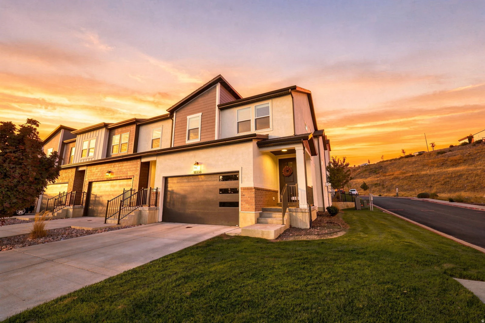 Modern townhome with attached garage, landscaped lawn, and a covered entry