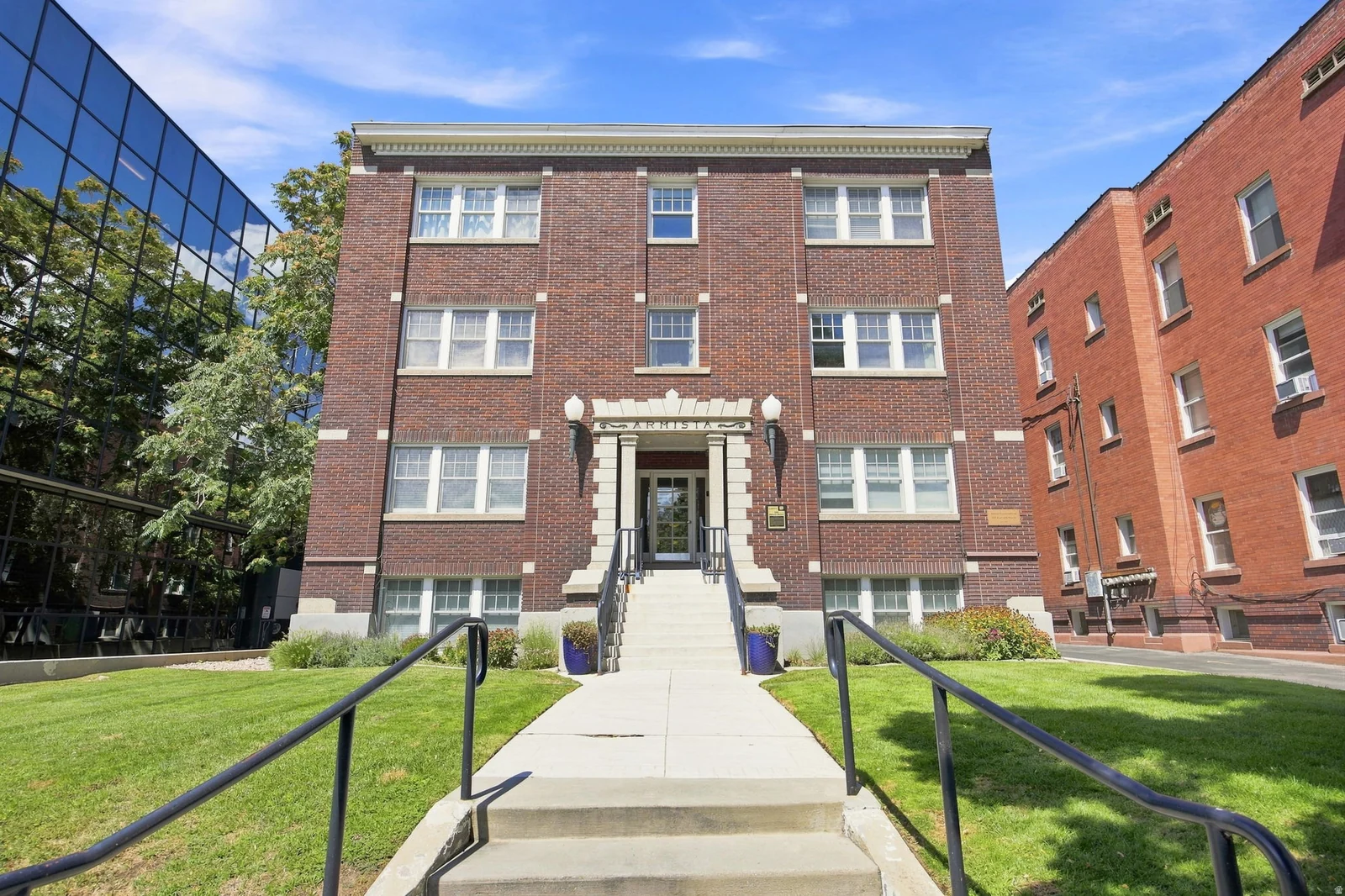 Brick exterior featuring multiple levels, stone entryway, and a concrete walkway with handrails