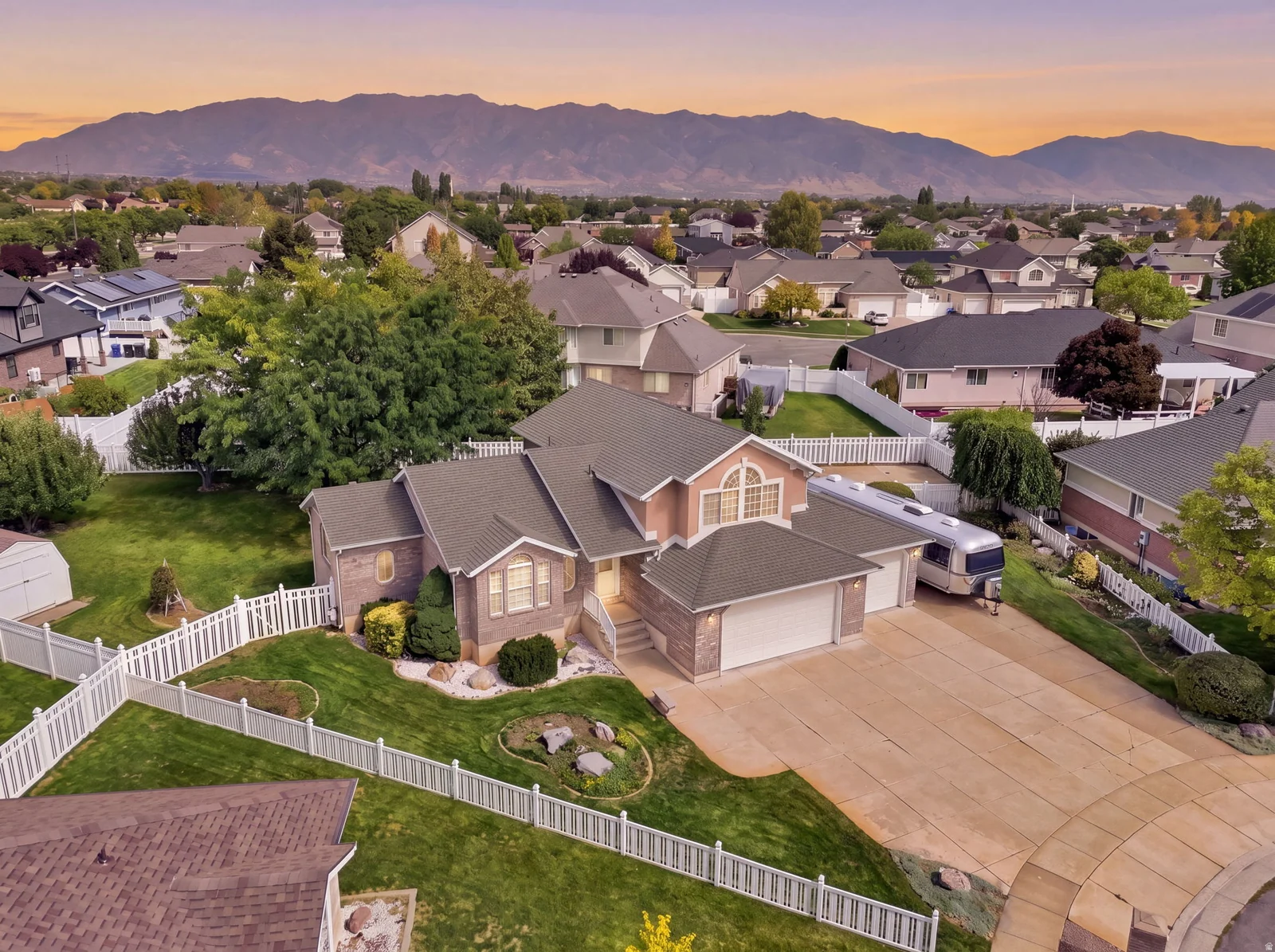Property with a brick and siding exterior, multi-car garage, and a fenced yard